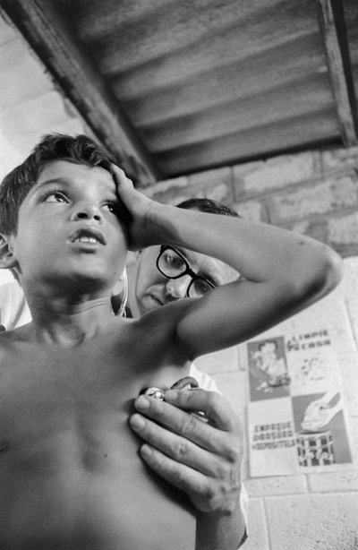 SSホープ号で聴診器を使って病気のエクアドルの子供を診断するアメリカ人医師 作： Ted Spiegel