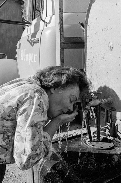 トラック運転手のミルドレッド・クーパーは、路上の埃で顔を洗っている。 作： Ted Spiegel