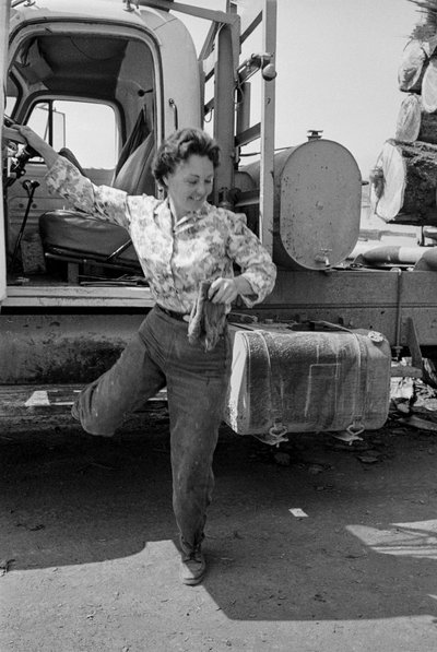 伐採トラックの運転席から降りる女性トラック運転手ミルドレッド・クーパー 作： Ted Spiegel