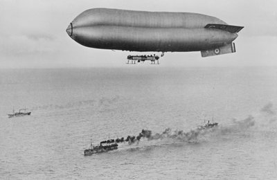RNAS沿岸クラス飛行船C23Aが軍艦護送船の上を飛んでいる、1917年頃 作： Thomas E. and Horace Grant Grant
