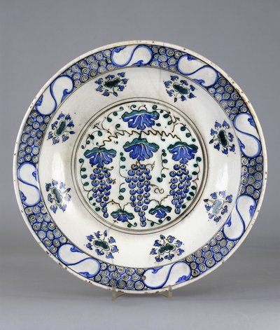 三つの葡萄の房と蔓の葉を描いた円形の中央部を持つイズニック陶器の皿、1570年頃（陶磁器 作： Turkish School