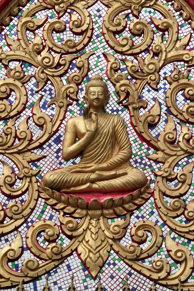 20151102、バンビエン、ラオス 。金のレリーフで装飾された入り口のドア。釈迦の生涯のある瞬間、すなわち釈迦が悟りを開いた後に行った最初の説教を描いた「教えの仏陀」。 作： Unbekannt