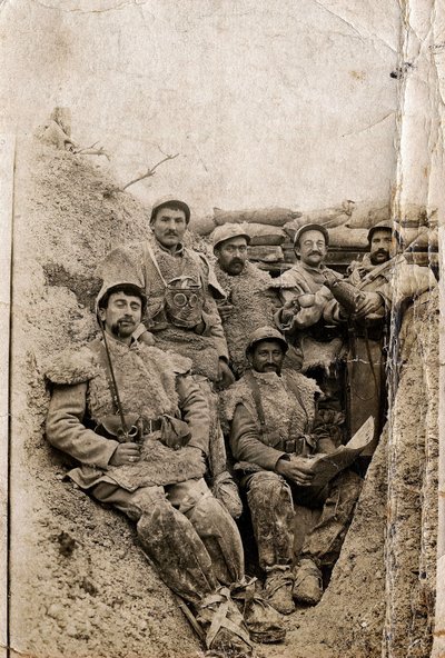 第一次世界大戦（1914-1918）：1916-1917年、塹壕の中で冬服を着た毛むくじゃらの兵士たち。シープスキンのジャケットとガスマスクを着用している。 作： Unbekannt