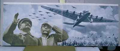 作家の名前を冠した飛行機を見学するジョセフ・スターリン（1879-1953）とマキシム・ゴーリキー（1868-1936）、『L.U.R.R.S. en construction』1935年1月号のイラスト（カラー写真 作： Unbekannt