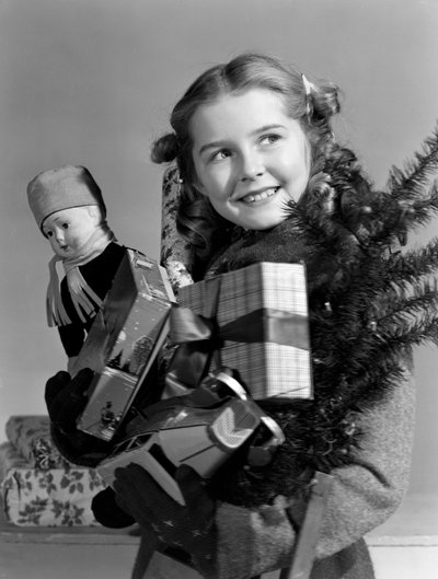 腕一杯のクリスマス・プレゼントを運ぶ少女（1950年頃 作： Unbekannt
