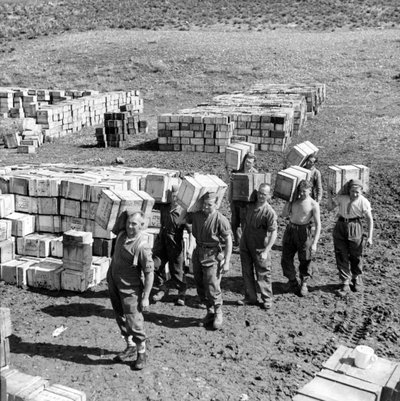 堆肥化された配給基地とそこに多くの物資を運ぶ男たち（1943年3月）（ランタンスライド 作： Unbekannt
