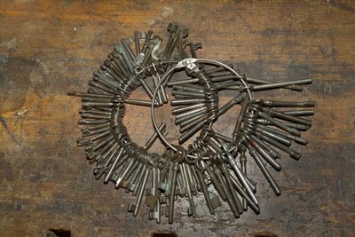 木製の机の上に置かれたリングの上の古い鍵の束（写真 作： Unbekannt