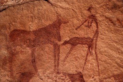 ロックアート、先史時代。エジプト、ウワイナット山塊にある、装飾されたシェルターの中の牛、子牛、キャラクター（射手）の岩絵。(紀元前8000年から3000年の間に描かれたもの。)写真 作： Unbekannt