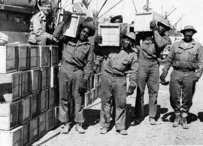 第二次世界大戦（1939-1945） - 中東 1943年4月。港で、米軍のポート大隊のメンバーがアフロ・アメリカンを形成して軍需品を降ろしている。 作： Unbekannt