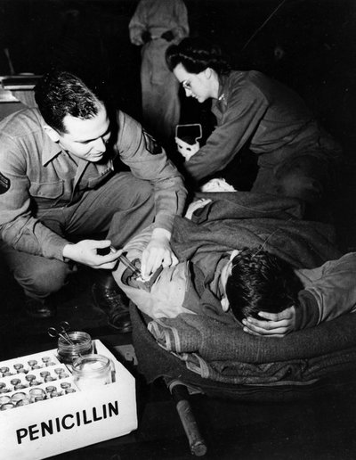 第二次世界大戦（1939-1945） - 第二次世界大戦（WWIIまたはWW2）。1945年2月のルクセンブルグ。米軍の避難病院で、衛生兵（看護師）が負傷した兵士にペニシリンを投与して感染を防ぎ、看護師が手術の準備をしている様子 作： Unbekannt