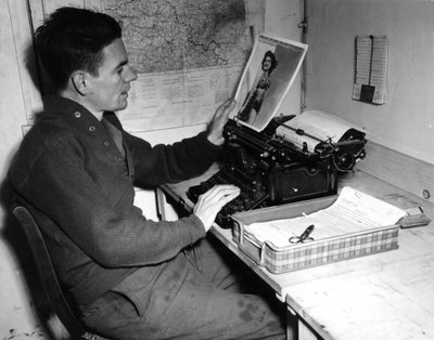 第二次世界大戦（1939-1945） - 第二次世界大戦（WWIIまたはWW2）。1944年12月1日、フランスのムツィヒ（アルザス地方）。Beachead News（GIのニュース誌）の記録係であるCorporal Flanertyが、次号に掲載するピンナップ写真を見ている。 作： Unbekannt