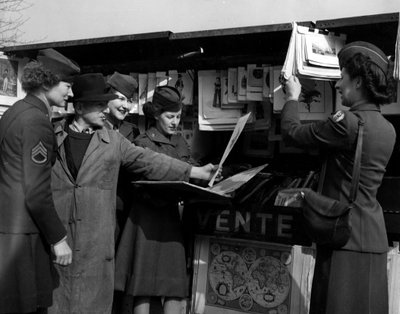 第二次世界大戦（1939-1945） - World War II（WWIIまたはWW2）。パリ（フランス）1945年3月。セーヌ川のほとりで、本を読む人と議論するアメリカ陸軍の4人のワック（女性陸軍部隊）。 作： Unbekannt