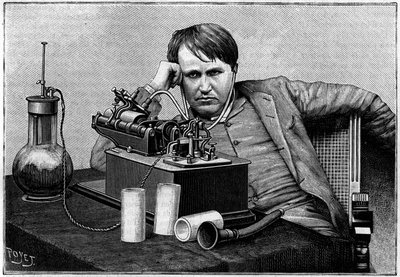 アメリカの物理学者トーマス・エジソン（1847-1931）がニューヨークで、イギリスから送られてきた最初の「フォノグラム」を聞いている様子。グーロー大佐が『ラ・ナチュール』に伝えた写真より）。La Nature: revue des sciences et leurs applications aux arts」に掲載された版画 作： Unknown artist