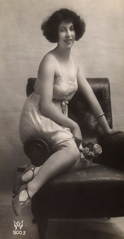 肘掛け椅子に座り、ペチコート姿でポーズをとる若い女性。 作： Unknown photographer