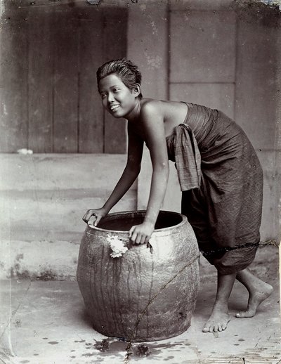 大きなコンテナを押しながら微笑む若いタイ人女性 作： Unknown photographer