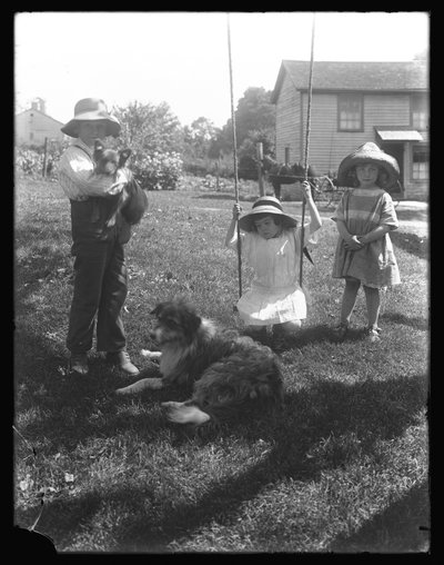 1913年頃、ペンシルベニア州のマクレディファームでロープスイングの周りに犬と子犬を連れた子供たちが集まりました。 作： William Davis Hassler