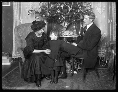 1912年のクリスマス、クリスマスツリーの下に座ったダンシーモアと非公式のポーズの家族 作： William Davis Hassler