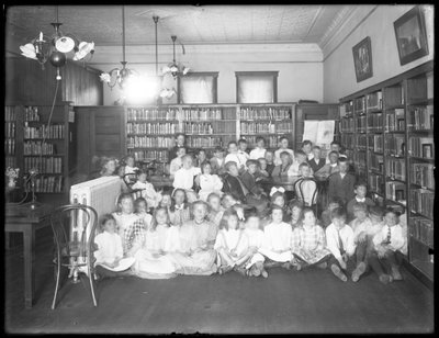 1910年頃、クイーンズボロ公共図書館の正体不明の支部の読書室にいる子供たちのグループの肖像 作： William Davis Hassler