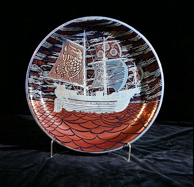 赤色の海に帆を張るガレオン船を描いた銀色光沢のチャージャー（陶製） 作： William de Morgan