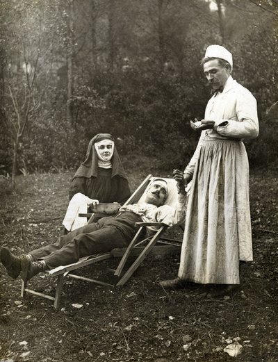 1900年頃、修道女看護師の助けを借りて、負傷した男性の脈をとっている医師（白黒写真） 作： . .