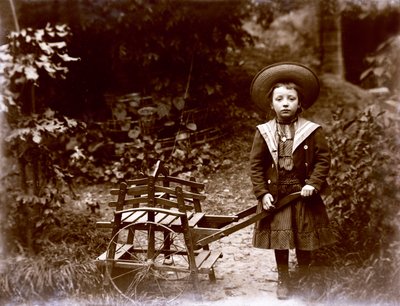 庭でカートを持つ少女、20 世紀初頭 (白黒写真) 作： . .