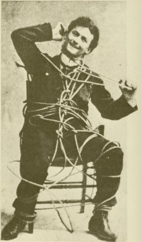 1898年、ロープを使った脱出トリックを披露する若き日のハリー・フーディーニ（モノクロ写真） 作： アメリカの写真家