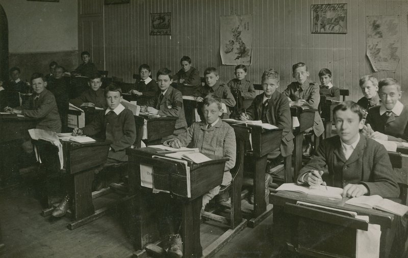 学校の授業中に机の後ろに座っている男性生徒 作： 英語の写真家