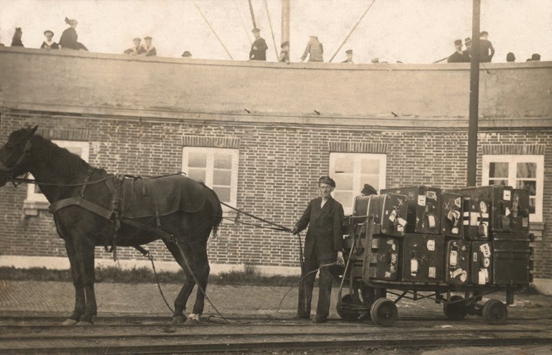 波止場で馬車の荷物用トローリーを持つポーター（モノクロ写真 作： ヨーロッパの写真家