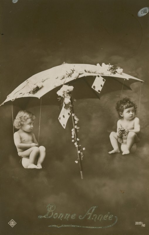 1913年に送られた、傘からぶら下がっている2人の赤ちゃんのハッピーニューイヤーカード 作： フランスの写真家
