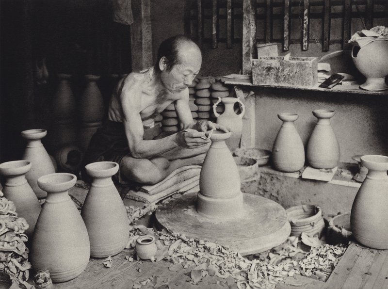 1920年代の日本。作業中のポッター（モノクロ写真 作： ハーバート・ポンティング