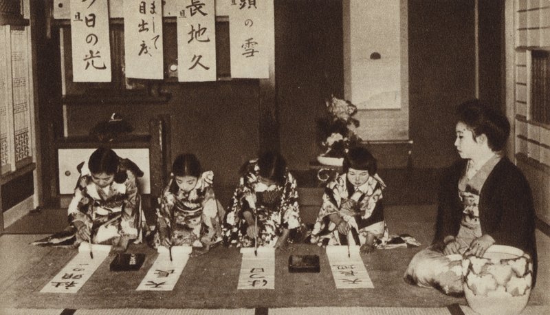 幼稚園のクラスで筆を使って文字を書く日本の女子生徒たち（モノクロ写真 作： 写真家日本人