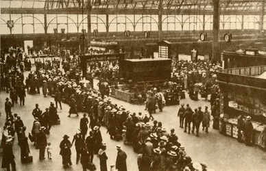 ロンドンのウォータールー駅で列車を待つ行楽客の列、1930年。