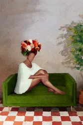 ソファに座る花を手にした女性