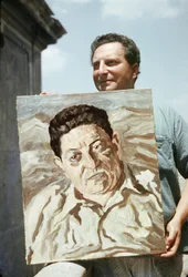イタリア人画家で作家のカルロ・レヴィ（1902-1975）は、作品のひとつである労働組合員ジュゼッペ・ディ・ヴィットリオの肖像画を手にする（写真）。