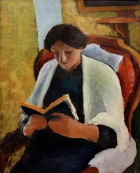 赤い肘掛け椅子で読書する女性