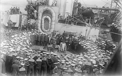1916年5月21日、イギリスのデボンにある造船所のHMASオーストラリアのデッキで演説するオーストラリアの首相、ホン・ウィリアム・モリス（ビリー）ヒューズの周りに船員が群がる