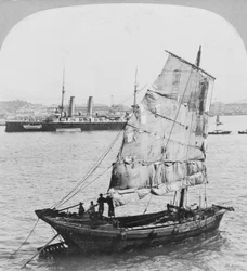 1902年に香港の港で中国のジャンクとイギリスの戦艦