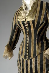 イブニング・ドレス、1884年頃（部分的に側面からの斜視図）。シルクサテンとカットベルベット、レース、絹糸のタッセルとフリンジ。チャールズ・フレデリック・ワース、フランス。