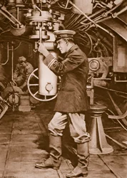 敵の目標を見つけるために潜望鏡を調べるイギリスの潜水艦士官