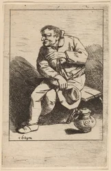 右手に帽子をかぶって座っている男性