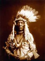 Weasel Tail, Piegan, com um Tomahawk, c. 1900, foto Edward S. Curtis