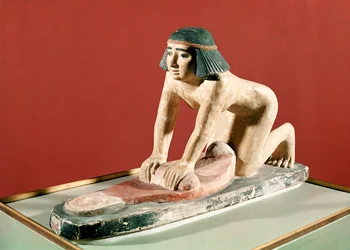 穀物をひく女性の模型、古王国時代（彩色石）