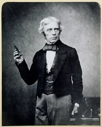 棒磁石を持つマイケル・ファラデー（1791-1867）。