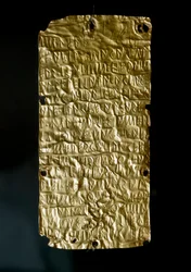 エトルリア古代美術：エトルリア語の銘文が刻まれ、統合された女神に捧げられたピュルギ出土の金製板（薄板）。紀元前6世紀末から紀元前5世紀初頭。寸法：18.5センチメートル。ローマ、ヴィラ・ジュリア国立博物館