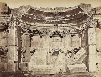 古代シリアの都市、ヘリオポリスまたはバールベック（現在のレバノン）の考古学地帯にある、いわゆる「部屋」の詳細。遺跡の上に座ってポーズをとる男性