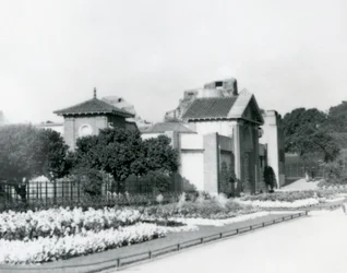 1928年のロンドン動物園の爬虫類館、入り口の小道に沿って正式な花壇がある（ロンドン動物園