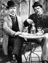 カフェのテラスに座ってアブサンを飲むシャトラン（Ducos）とそのコーチマン - 写真、1890年頃
