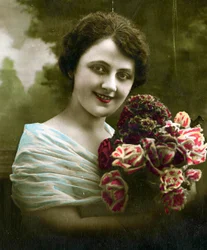 花の束を保持している女性の肖像画c。 1898（手彩色写真）