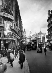 1930 年代初頭、ロンドン、ウェストミンスター、チャリング クロス ロードのアストリア劇場を通り過ぎる人々。