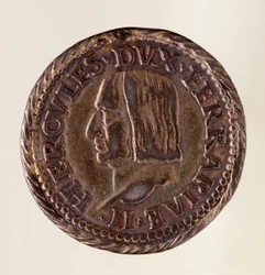 フェラーラの銀貨（テストーネ）：エルコレ1世・デステ公（ヘラクレス1世・デステ）の治世（1471-1505）。直径：3センチメートル。ローマ、国立浴場博物館